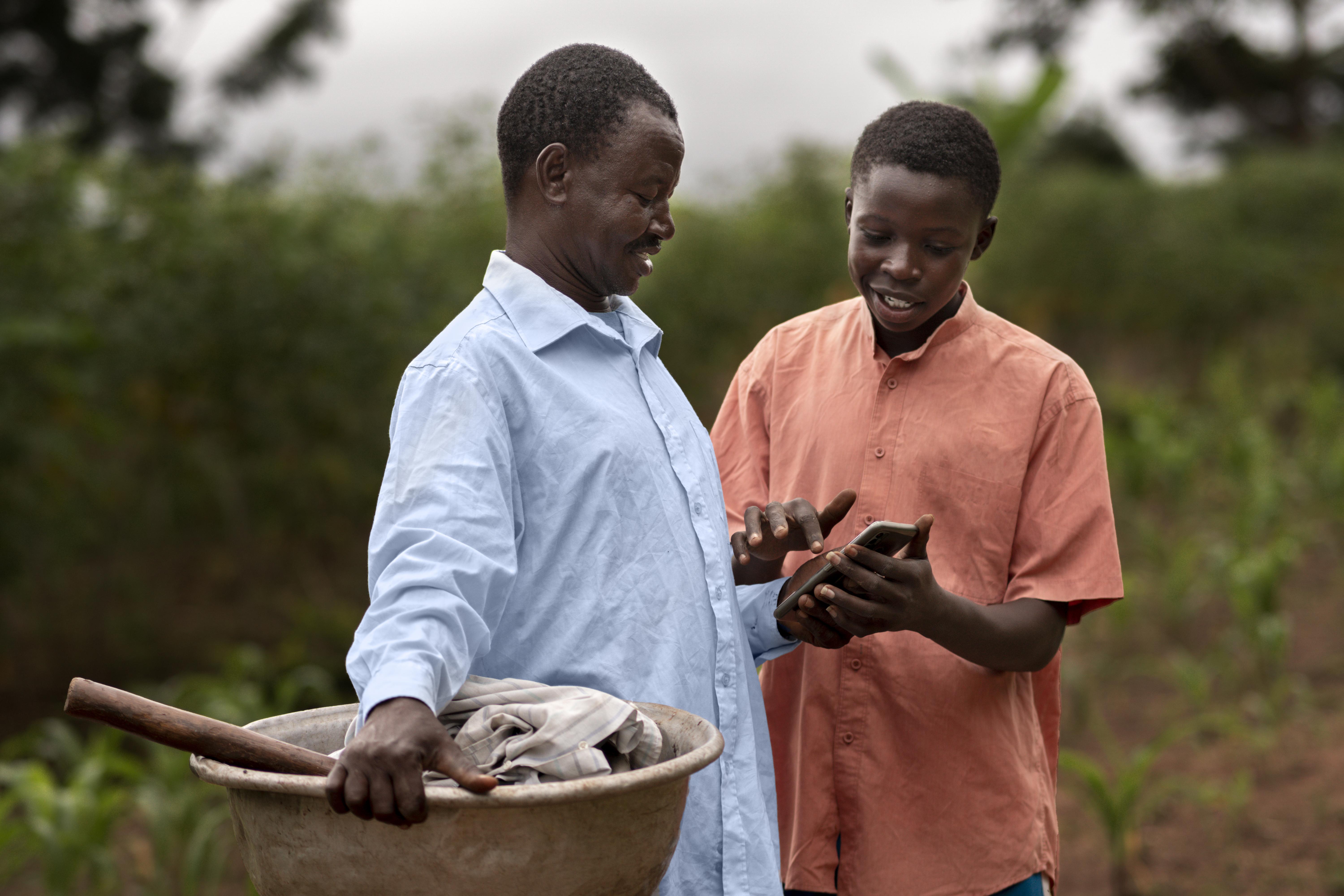 A farmer shaking hands with a financial professional in a lush cocoa farm, symbolizing partnership and growth.